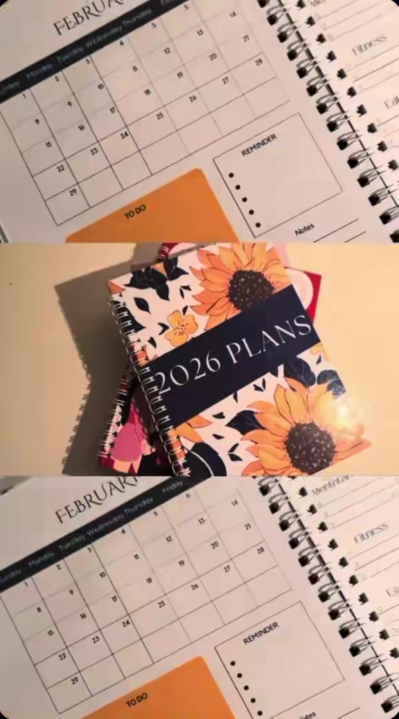 Open planner monthly spread beside the 2026 cover